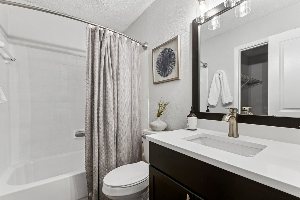Bathroom A bathroom with a white sink, toilet, and a shower with a grey curtain at Elme Druid Hills, Atlanta, Georgia